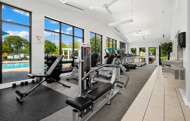 A gym with a row of treadmills and exercise machines.