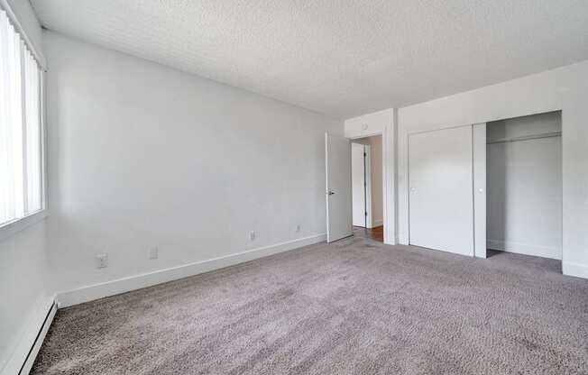 a bedroom with white walls and carpet