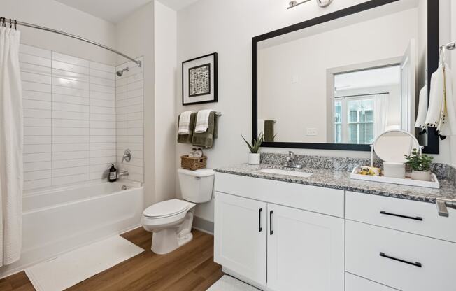 a bathroom with a large mirror and a toilet and a bath tub