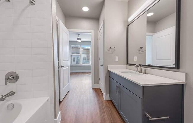A bathroom with a white sink and a white bathtub.