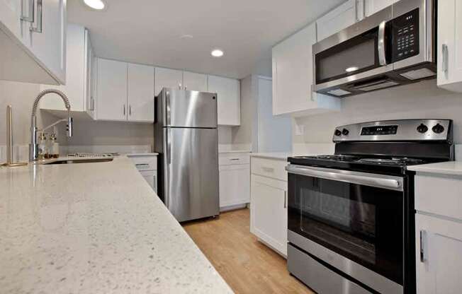 A modern kitchen with stainless steel appliances and white cabinets.