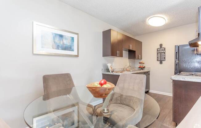A modern kitchen with a glass table and chairs.