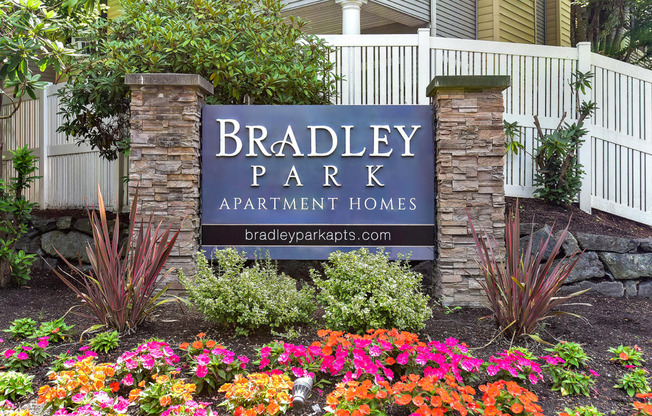a sign apartment homes in front of flowers