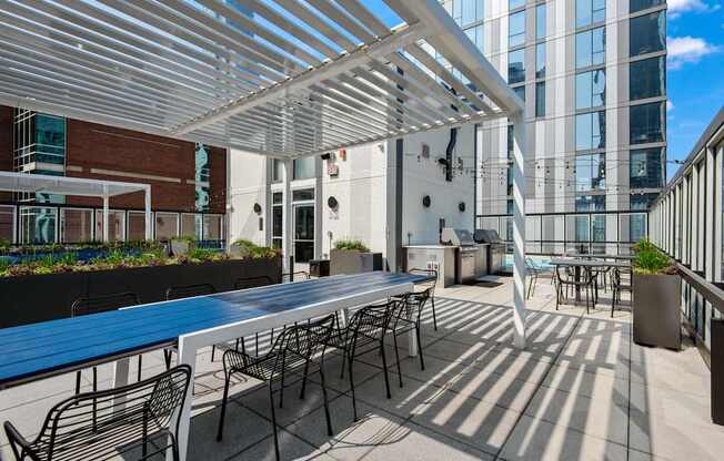A patio with tables and chairs is covered by a white roof.
