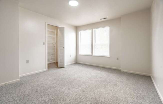 A room with a carpeted floor and a door leading to another room