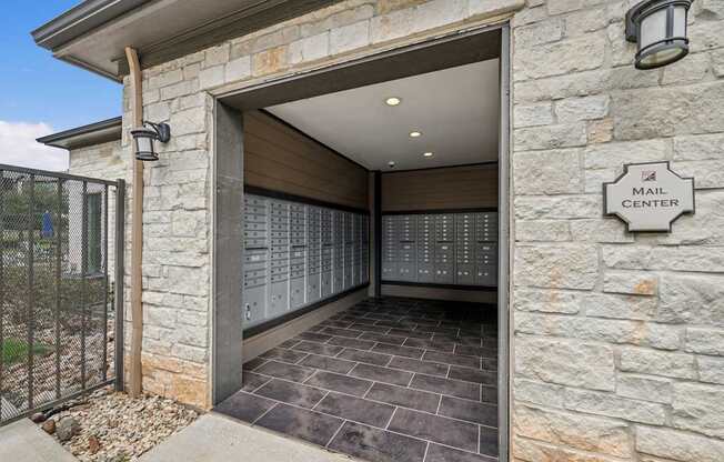 A mail center is located in a stone building with a large, open door.
