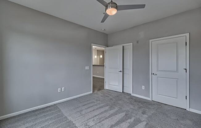 a bedroom with two doors and a ceiling fan at Nexus at Sandhill, South Carolina