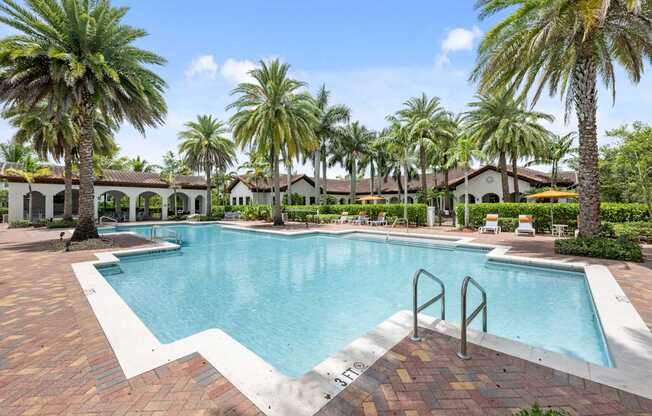 a large swimming pool with palm trees in front of a house