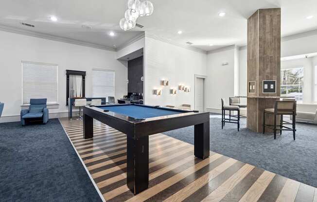 A room with a pool table and a striped carpet.