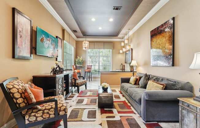 Resident lounge with a TV, couch, chairs, bar area with more seating