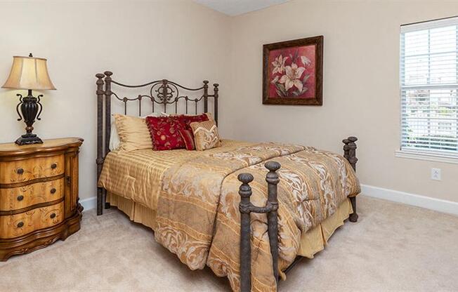 a bedroom with a bed and a dresser at Bedford Parke Apartments, Warner Robins Georgia