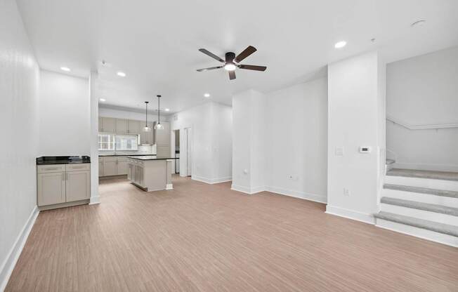 A spacious room with a ceiling fan and lighting fixtures.