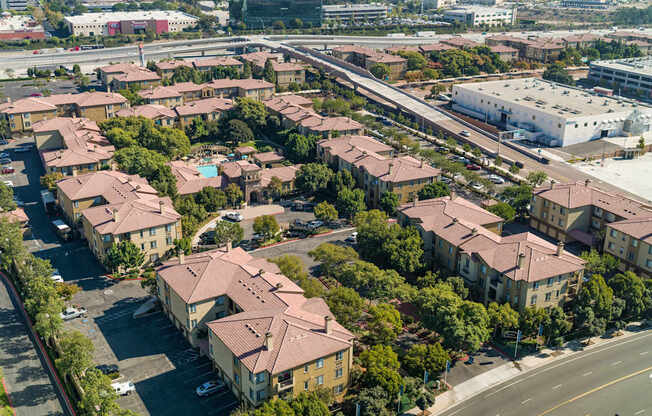 A large apartment complex with a parking lot in front.