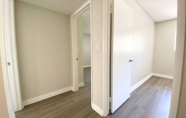 an empty living room with white walls and wood flooring