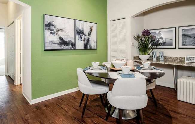 Dining nook with green accent wall and round table