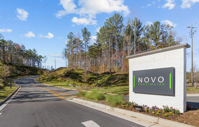 A street view of Novo Sweet Water with a white signboard.