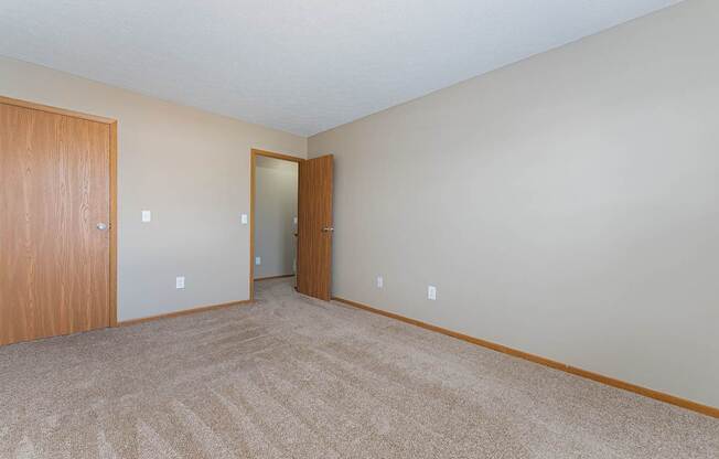 A room with carpeted floor and two doors