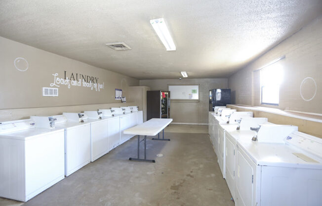 Laundry and dryer room with white washers and dryers.