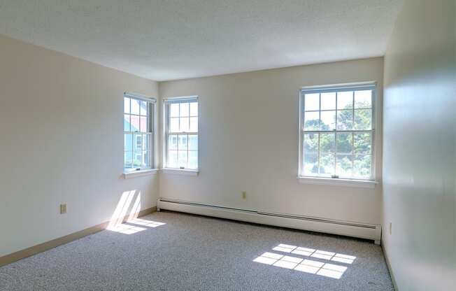 Carpeted Bedroom With Windows at Pondside at Littleton Apartments.
