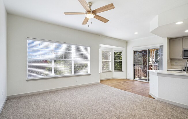 an empty living room with a ceiling fan and a kitchen at The Legends at Eagle Mountain Lake, Fort Worth, Texas