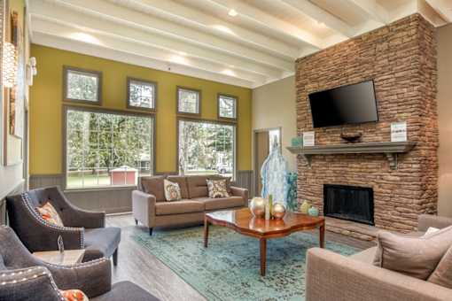 A living room with a fireplace and a flat screen TV mounted above it.