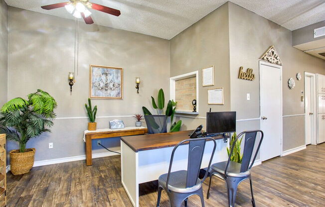 a home office with a desk and chairs and a computer