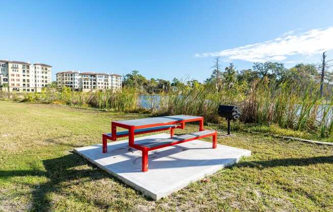 a picnic area with a picnic table and a grill in a park