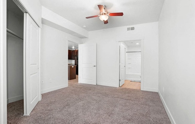 an empty living room with a ceiling fan