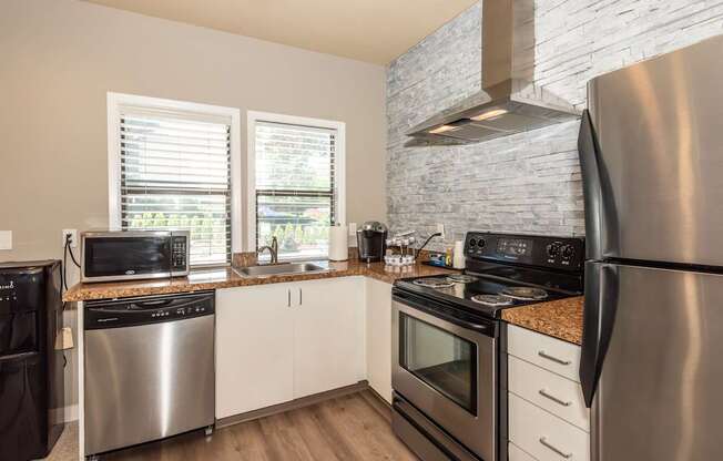A modern kitchen with stainless steel appliances and wooden floors at Sunstone Parc, Beaverton, OR, 97008