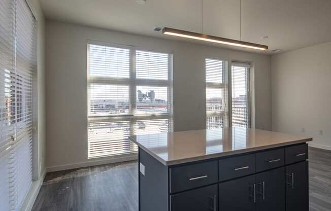 a view of a dining room with a large window and a table with black cabinets