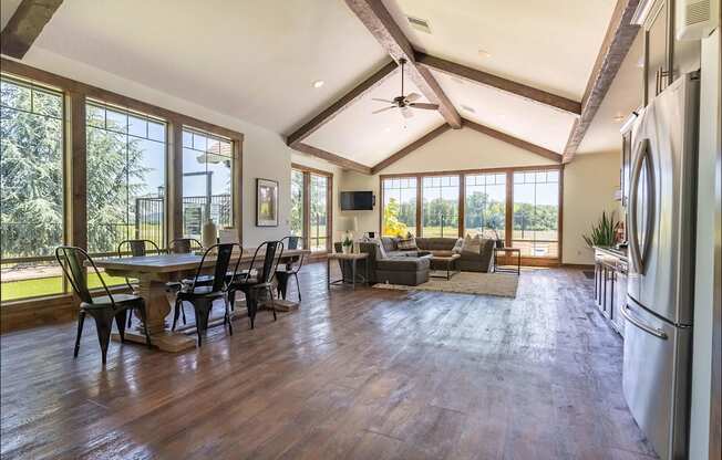 A spacious kitchen and dining area with wooden floors and a large window at Riverplace Apartment Homes, Independence, Oregon