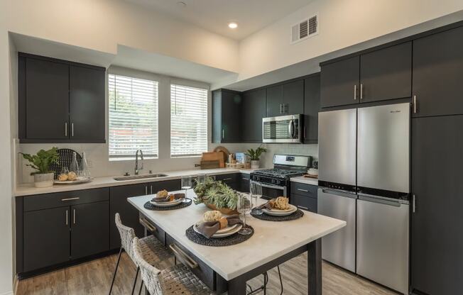 a kitchen with stainless steel appliances and a table with plates of food