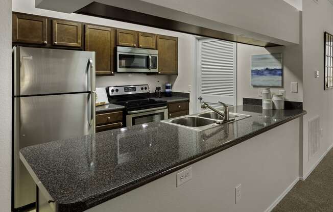 a kitchen with a granite counter top and stainless steel appliances