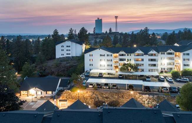 A large white building with a parking lot in front of it.