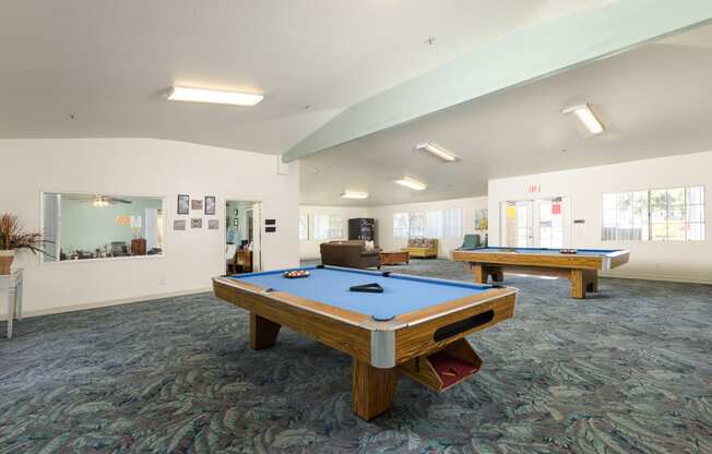 two pool tables in a community room with other amenities