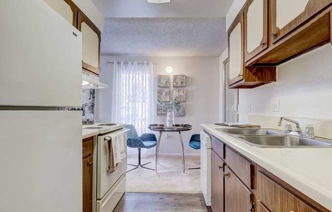 A kitchen with a white refrigerator and wooden cabinets.