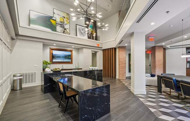 A modern kitchen with a black marble island and a dining table with chairs.