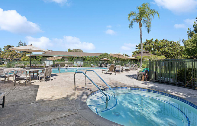 Swimming pool with chairs and tables and umbrellas at Walnut Creek Manor Apartments in Walnut Creek, CA