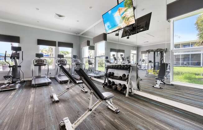 the gym is equipped with cardio equipment and televisions