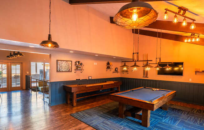 A room with a pool table and a bar area.