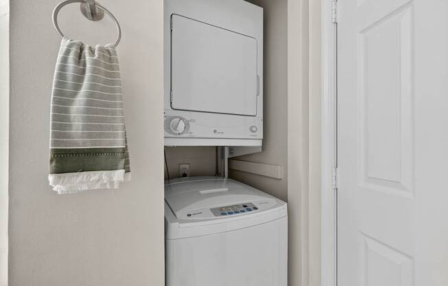 A white washing machine is in a small laundry room.