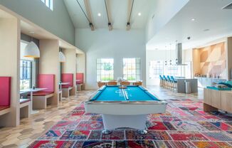 a pool table sits in the middle of a room with a bar in the background