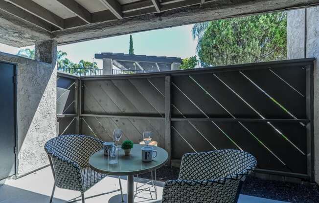 a patio with a table and chairs on a balcony at Aspire Upland Apartments, California