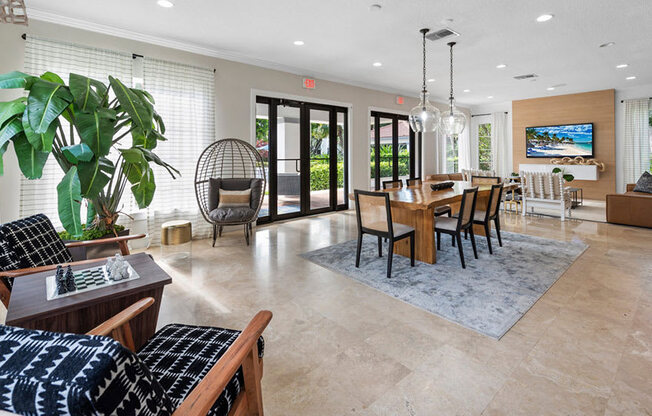 A living room with a black and white patterned couch, a wooden coffee table, and a large TV mounted on the wall.
