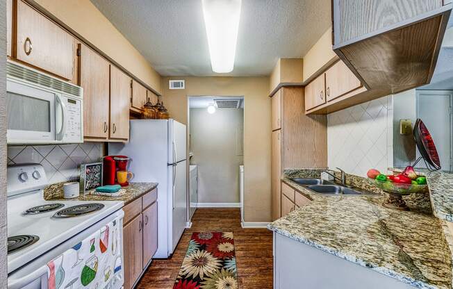 a kitchen with white appliances and granite counter tops