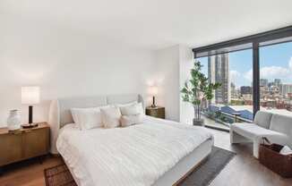 a white bedroom with a large bed and a view of the city at Cassidy on Canal, Chicago, IL, 60654