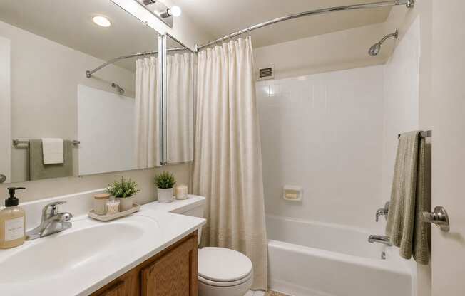 A bathroom with a white sink, toilet, and bathtub.
