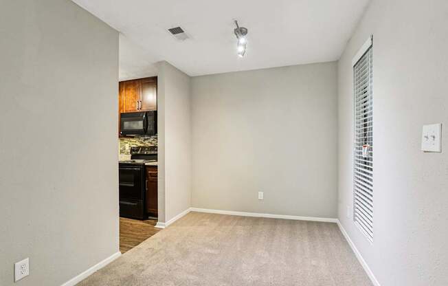 A room with a carpeted floor and a ceiling fan.