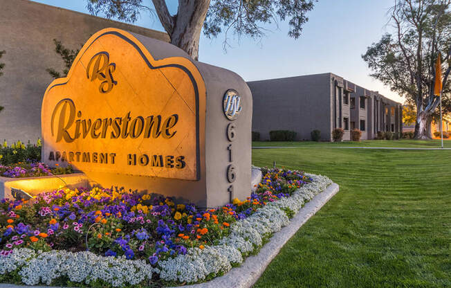 Riverstone community sign with lush landscape and flowers surrounding