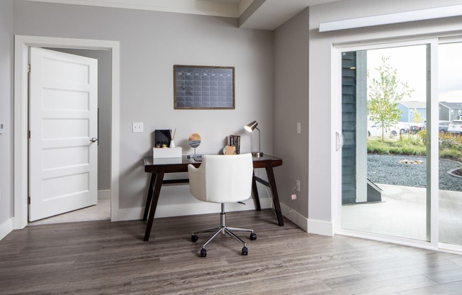 a home office with a sliding glass door leading out to a patio